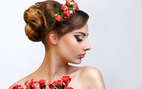 Красивая девушка с прической и венком из роз в волосах 