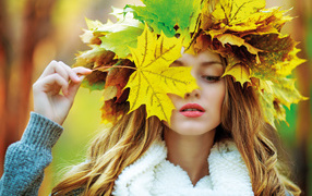 Красивая девушка с венком из листьев осенью