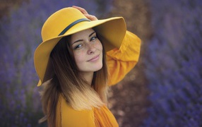 Красивая девушка с веснушками на лице в желтой шляпе