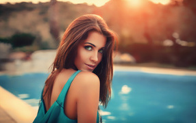 Beautiful green-eyed brown-haired woman by the pool