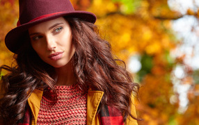 Красивая длинноволосая девушка в шляпе осенью