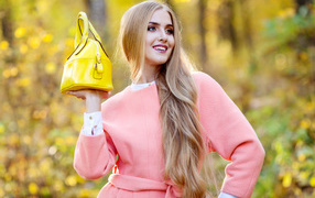 Красивая длинноволосая девушка с желтой сумкой осенью 