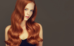 Красивая рыжеволосая голубоглазая девушка на сером фоне