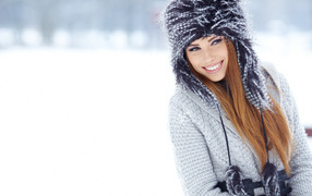 Красивая улыбающаяся девушка в  шапке зимой