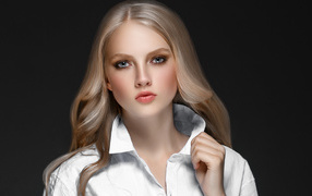 Красивая стильная голубоглазая блондинка в белой рубашке на сером фоне