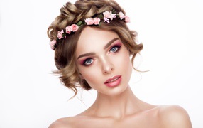 Beautiful tender blue-eyed girl with a wreath on her head on a white background
