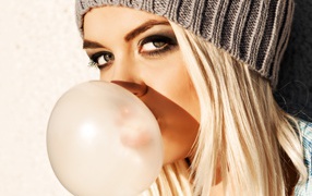 Девушка блондинка с жвачкой во рту крупным планом