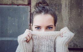 Blue-eyed girl covered her face with a sweater