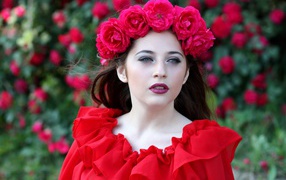 Яркая девушка в красном платье с венком из роз на голове
