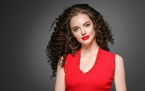 Яркая девушка в красной майке на сером фоне