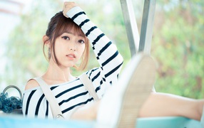 Кареглазая девушка азиатка в полосатом свитере