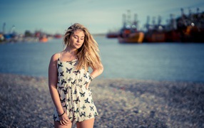 Милая блондинка на фоне моря в порту