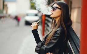 Girl in sunglasses blows smoke from his mouth