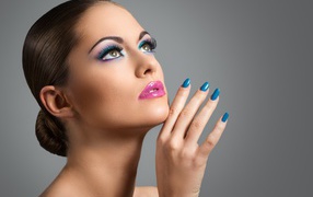 Девушка с ярким макияжем и синим лаком на ногтях 