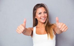 Счастливая девушка показывает класс на сером фоне