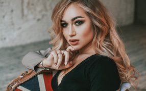 Горячая девушка с макияжем сидит на стуле