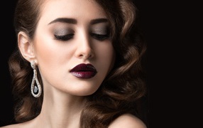 Длинноволосая девушка с ярким макияжем на черном фоне