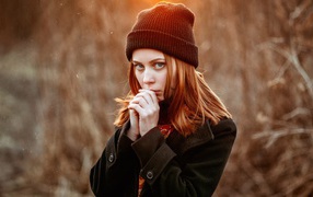 Рыжеволосая девушка в черной шапке в пальто 