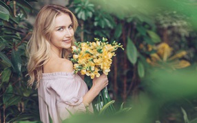 Улыбающаяся блондинка с букетом хризантем в руках