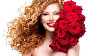 Улыбающаяся голубоглазая рыжеволосая девушка с букетом красных роз 