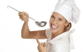 Улыбающаяся девушка в костюме повара с половником