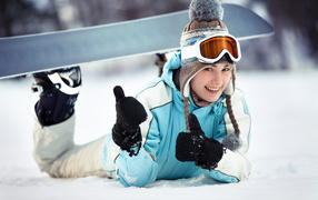 Улыбающаяся девушка сноубордистка на снегу зимой