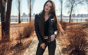 Stylish girl in a black jacket in the park