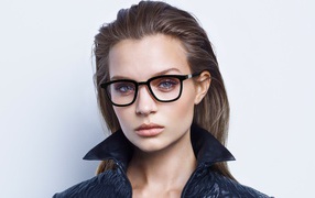 Стильная девушка в очках в черной куртке на сером фоне