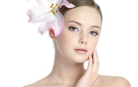 Нежная красивая девушка с лилией в волосах на белом фоне 