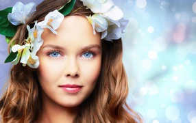 Tender blue-eyed girl with flowers in her hair
