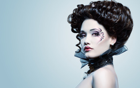 Девушка с необыной прической и макияжем на сером фоне