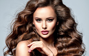 Девушка с красивыми длинными волосами на сером фоне