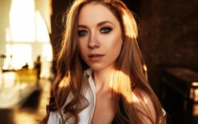 Лучи солнца нападают на волосы голубоглазой шатенки 