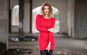 Молодая девушка в красном платье в старом здании