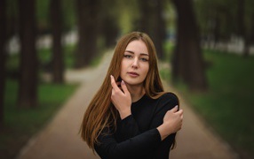 Молодая девушка в черном наряде в парке