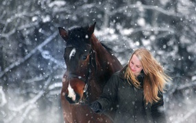 Молодая девушка с конем зимой 