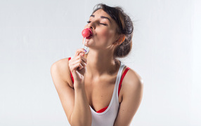 Молодая девушка с конфетой на палочке