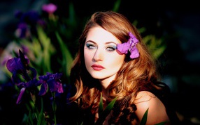 Молодая девушка с фиолетовым цветком ириса в волосах