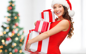 Улыбающаяся девушка в красном платье с подарками на новый год 