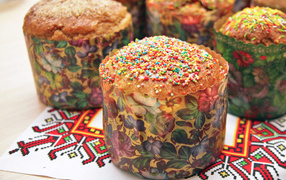 Вкусные сладкие куличи с посыпкой стоят на рушнике