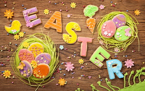 Вкусное разноцветное пасхальное печенье на деревянном столе