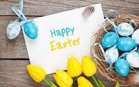 Надпись на белом листе Happy Easter с букетом желтых тюльпанов и крашенными яйцами