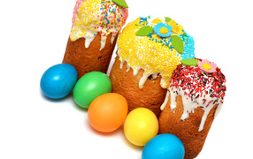 Три кулича с крашеными яйцами на белом фоне к празднику Пасха