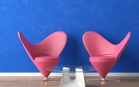 Два розовых кресла и стеклянный столик у синей стены 