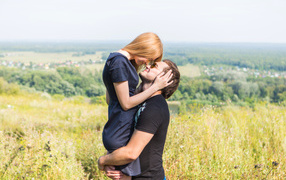 Влюбленная пара обнимается на поле 