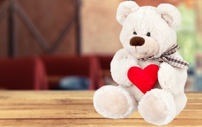 Белый плюшевый мишка с красным сердцем