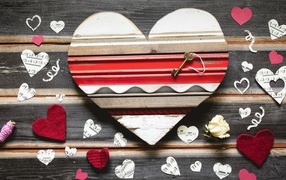Деревянное сердце с бумажными сердечками на столе