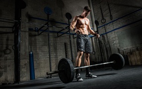 Мужчина спортсмен поднимает штангу в спортзале