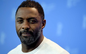 Британский актер Идрис Эльба на голубом фоне