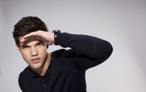 Красивый парень, актер Тейлор Лотнер на сером фоне